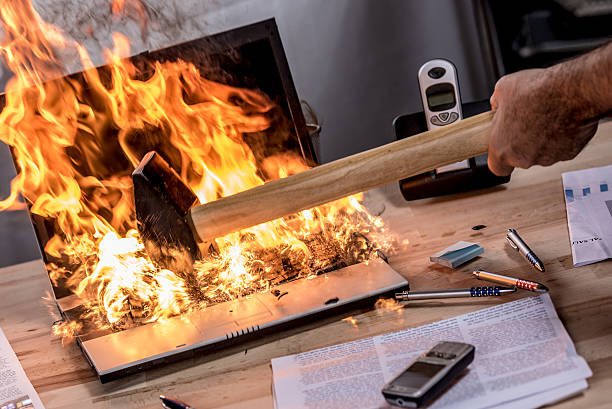 Burning laptop being smashed by a sledgehammer